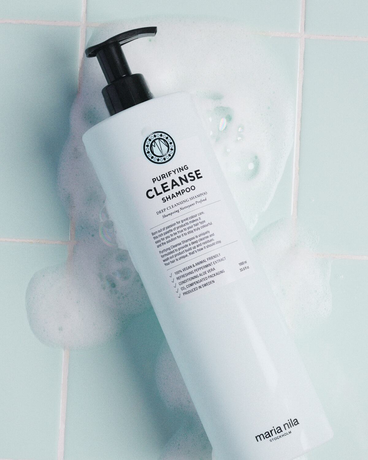 Purifying Cleanse shampoo bottle with lather