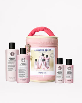 Maria Nila hair care products including bottles and a pink travel case on a white background