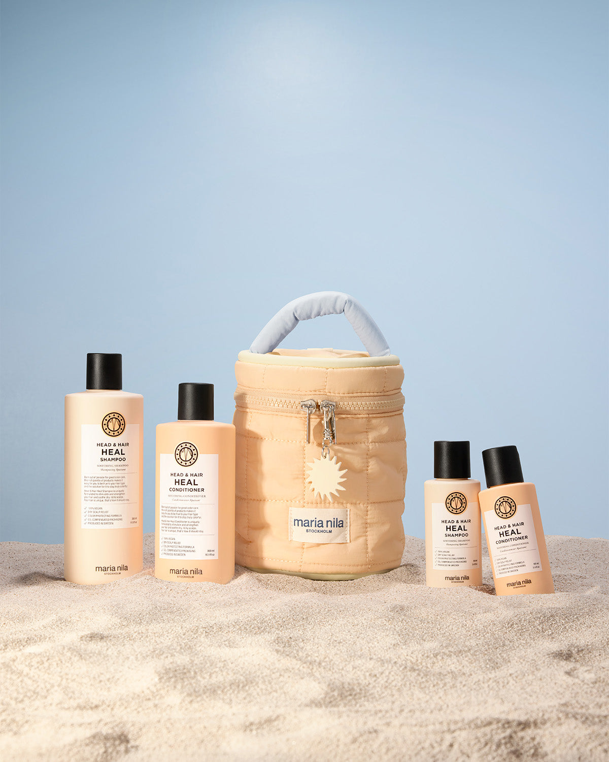 Set of Maria Nila hair care products including bottles and a Beauty Bag on a light blue background.