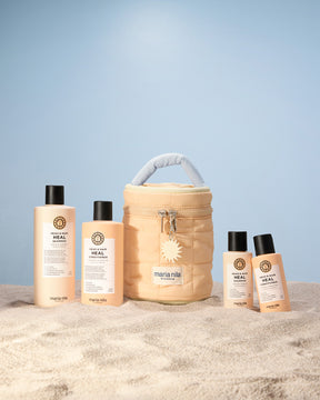 Set of Maria Nila hair care products including bottles and a Beauty Bag on a light blue background.