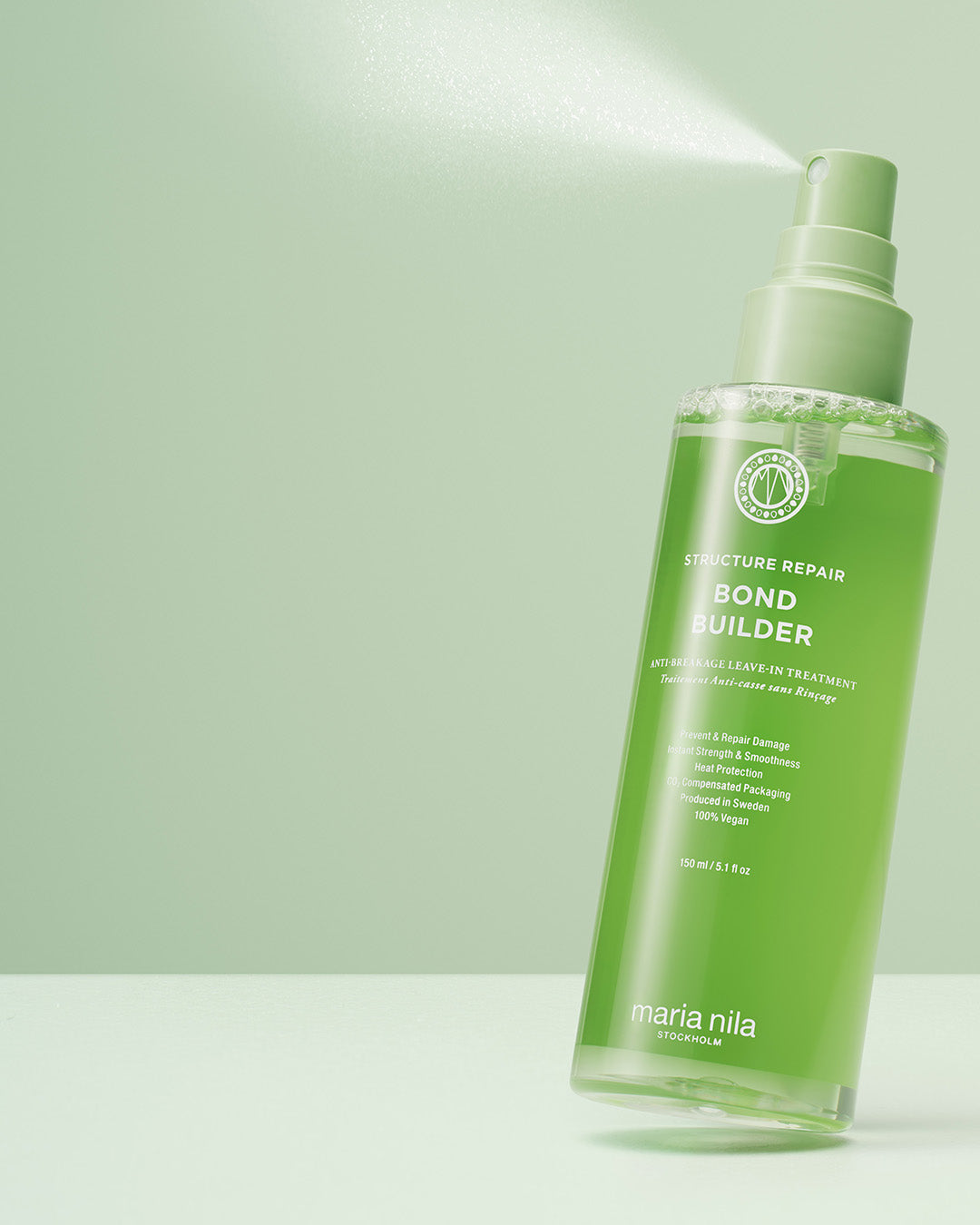 Green spray bottle with Maria Nila Bond Builder anti-breakage leave-in treatment a light green background