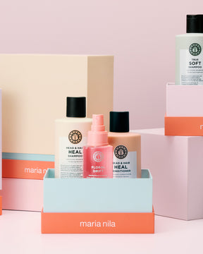 Maria Nila hair care products on a pink background